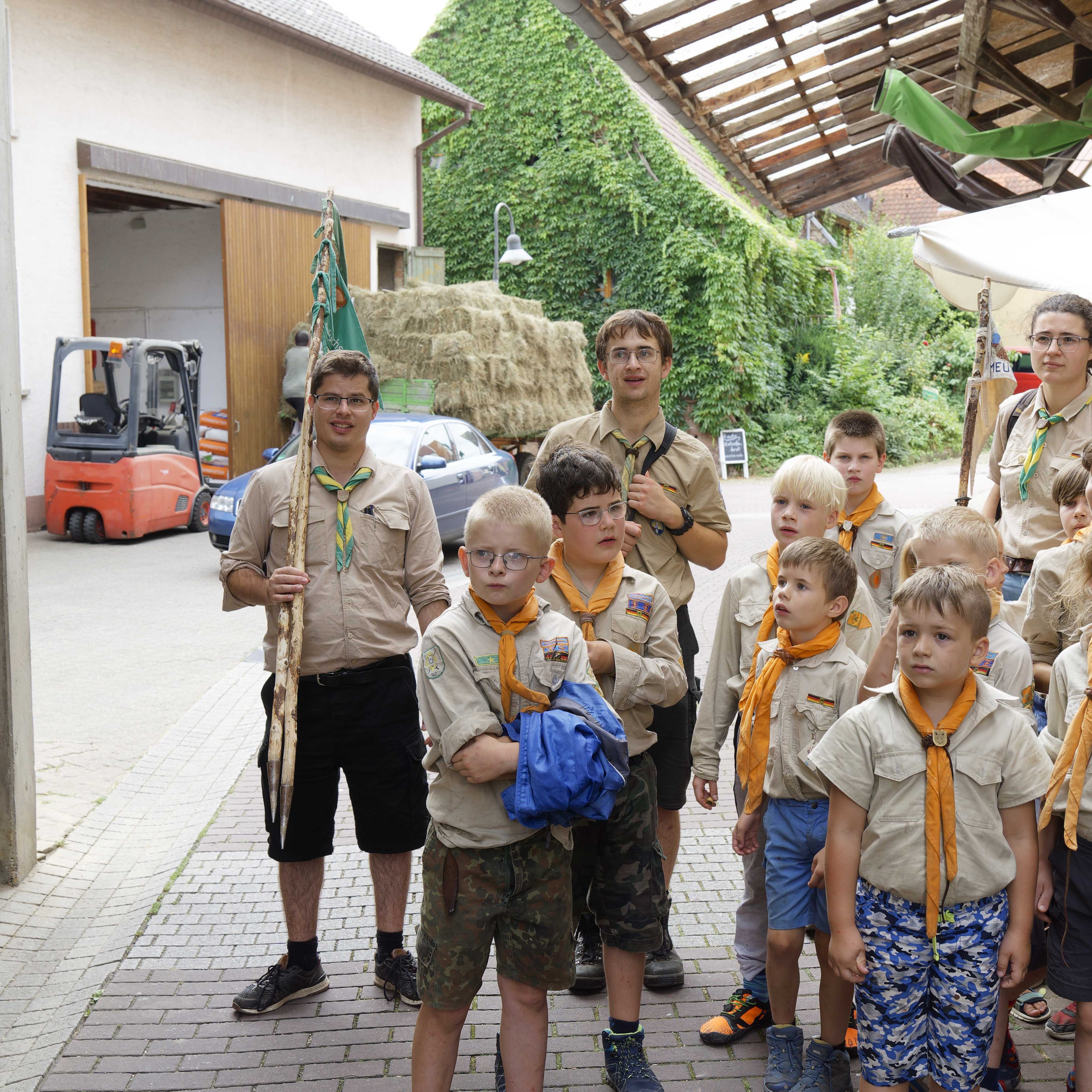 Gespannt blickt die Jugendgruppe auf einen Gegenstand im Hof der Mühle