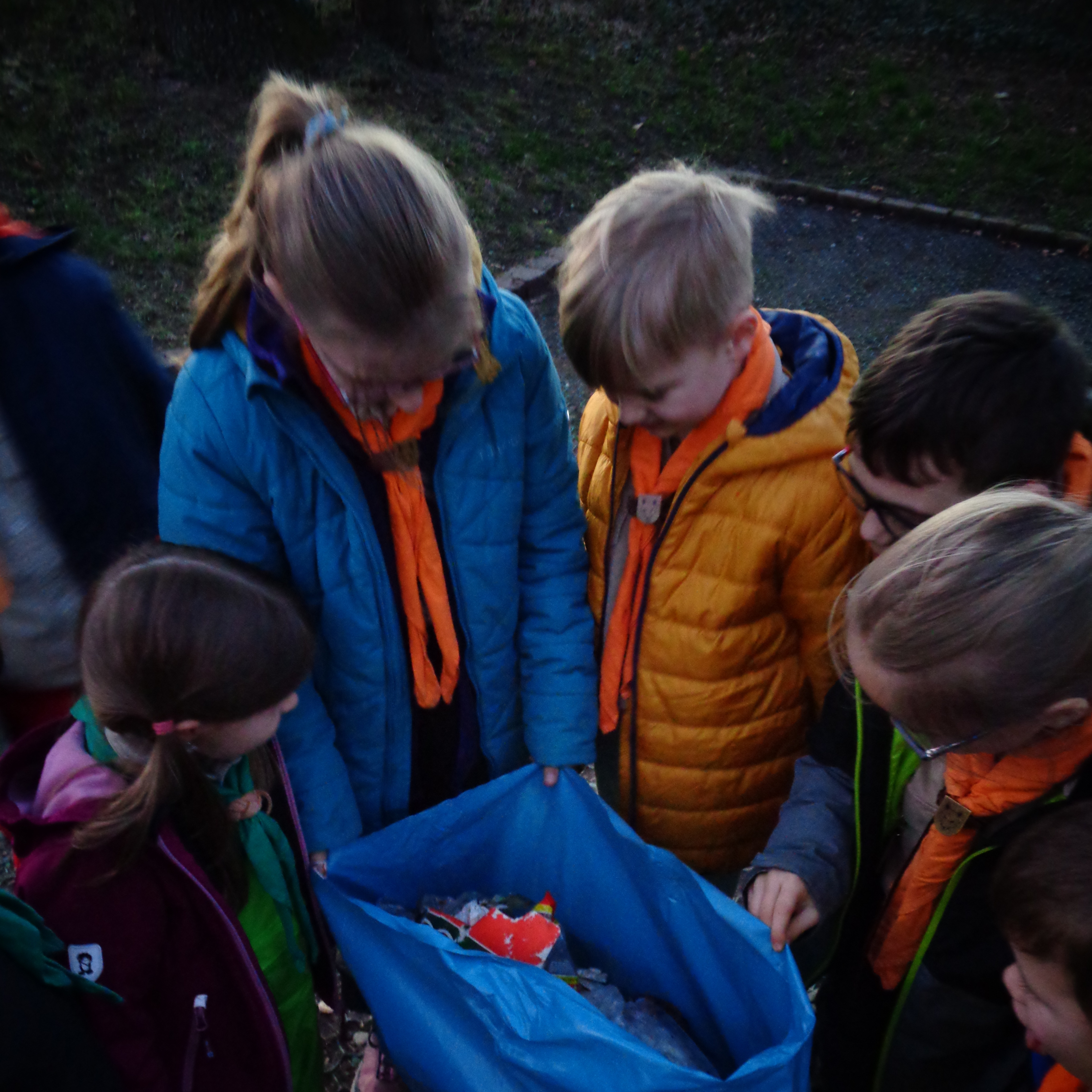 Kinder blicken in vollen Müllsack.